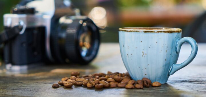 Coffee cup, beans and camera on a wooden table; illustrative photograph by Engin Akyurt on Pexels